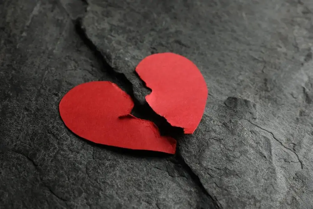 a borken heart imagge of paper on black background expressing Broken Heart Shayari In Hindi - Theshayarihub.com