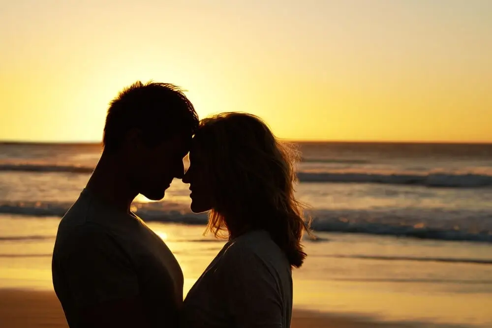 a couple loving each other on the beach while sunset Love Status in Hindi - Theshayarihub.com